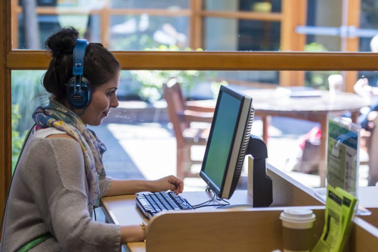 a woman using a computer and headset
